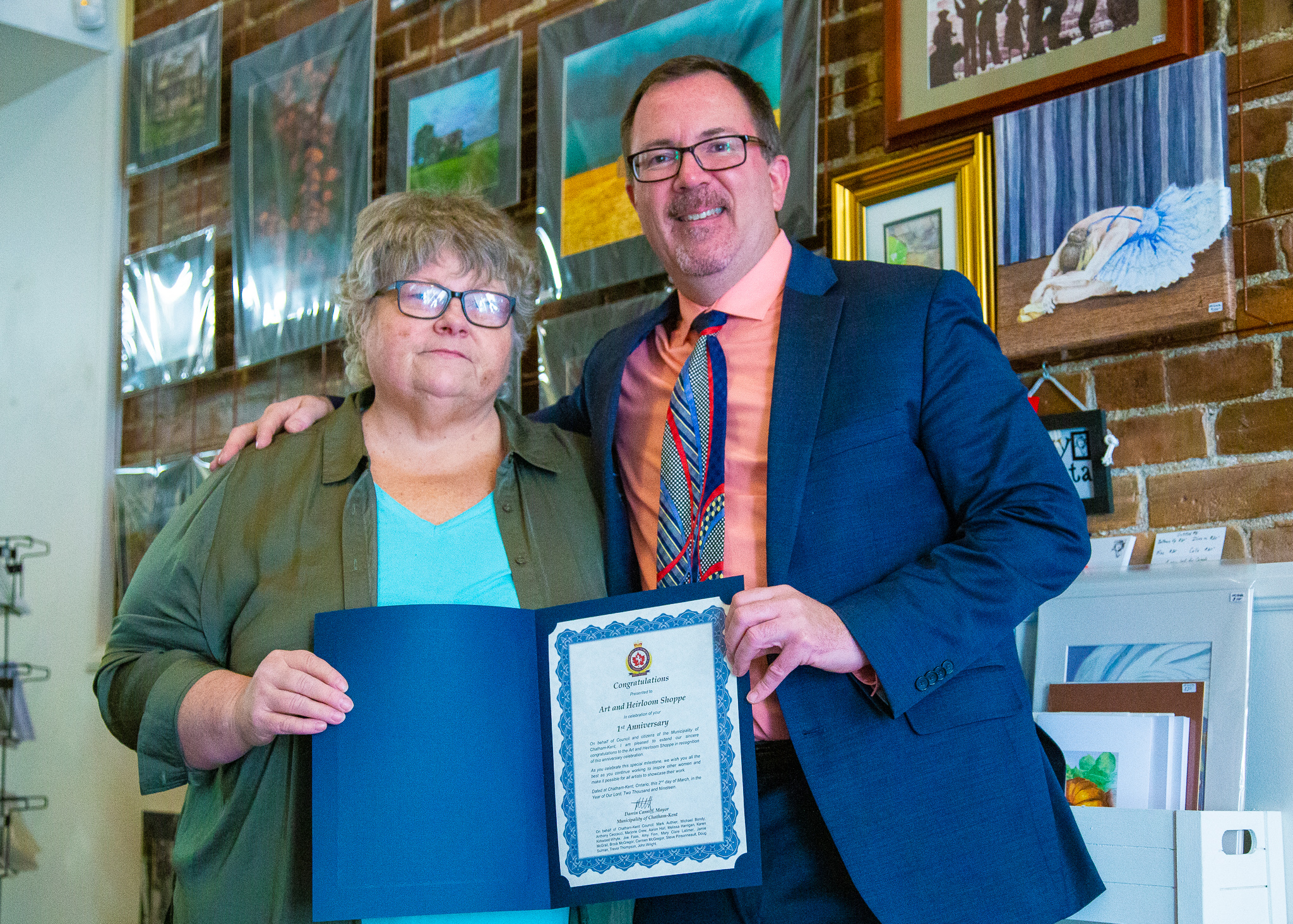Chris Ford, co-owner of the Art and Heirloom Shoppe, receiving a certificate of congratulations from Chatham-Kent Mayor,