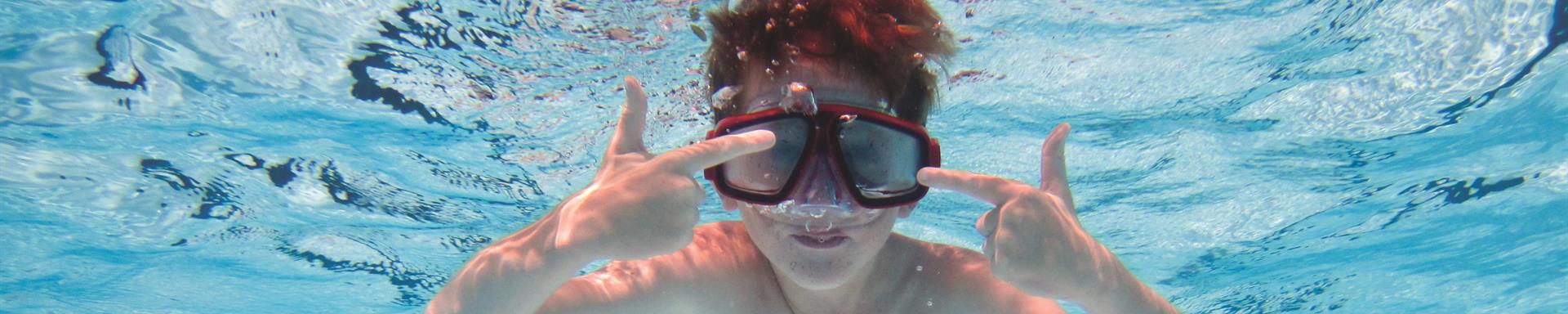 Young boy swimming underwater in a pool