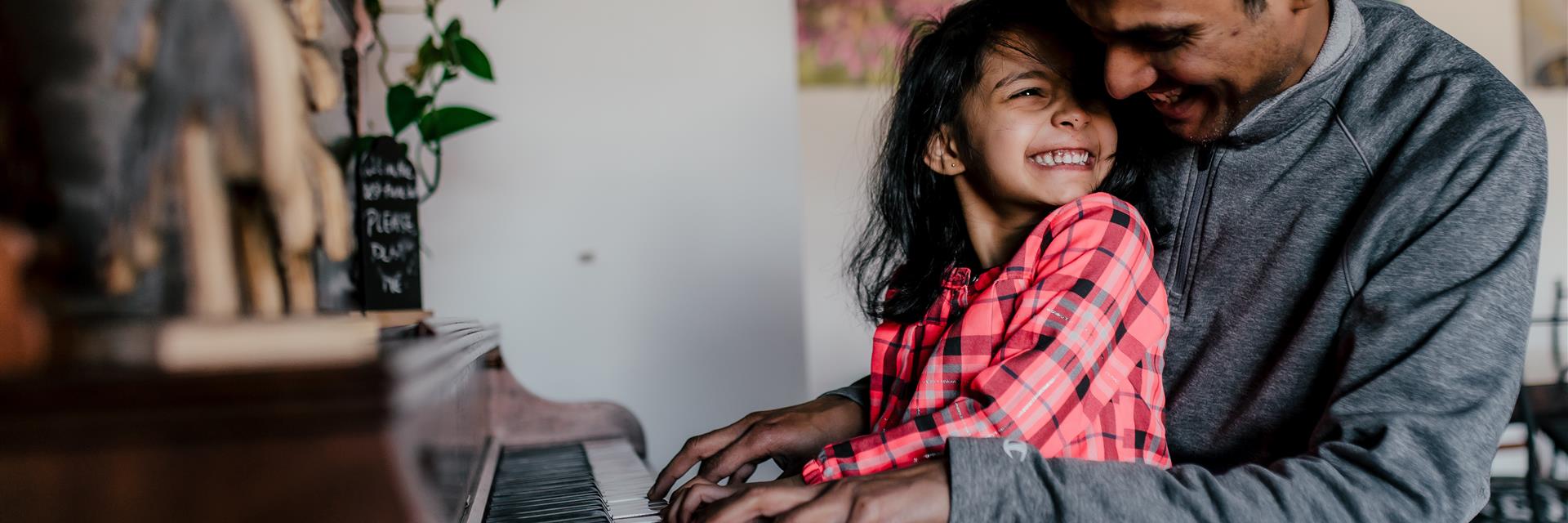 Father and daughter playing piano.