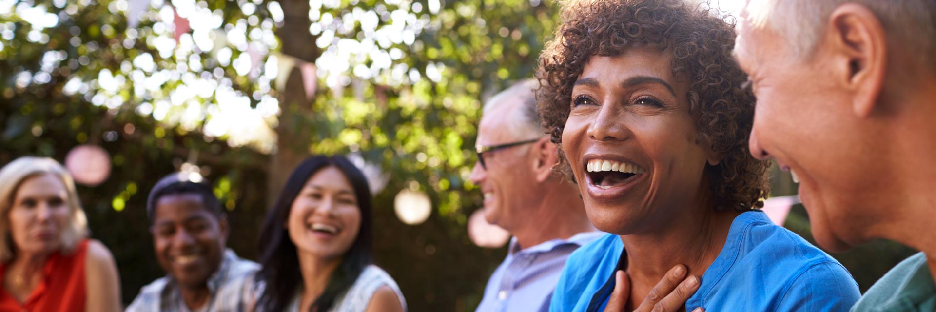 A group sitting in a park laughing.