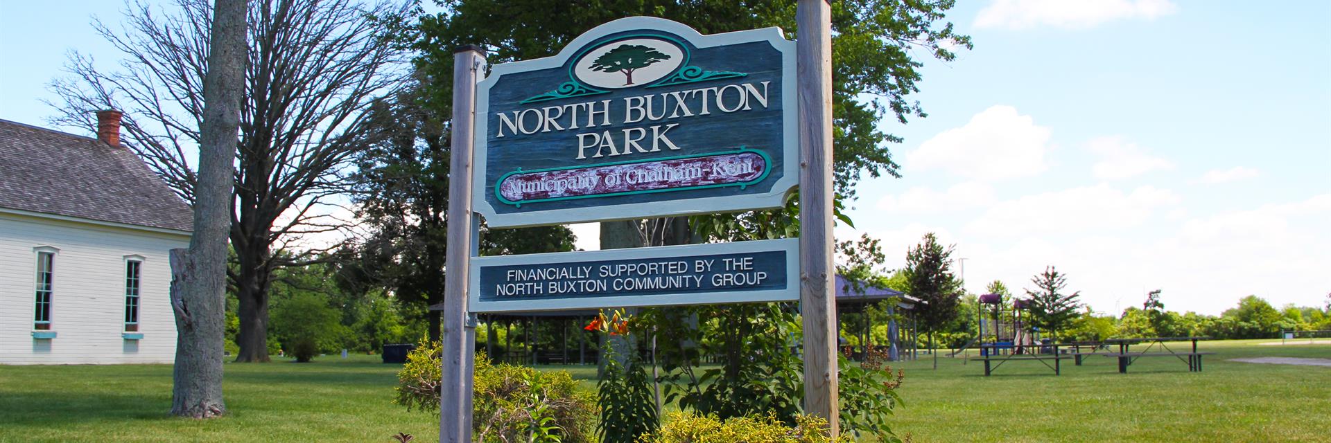 North Buxton Park sign in a flower bed.