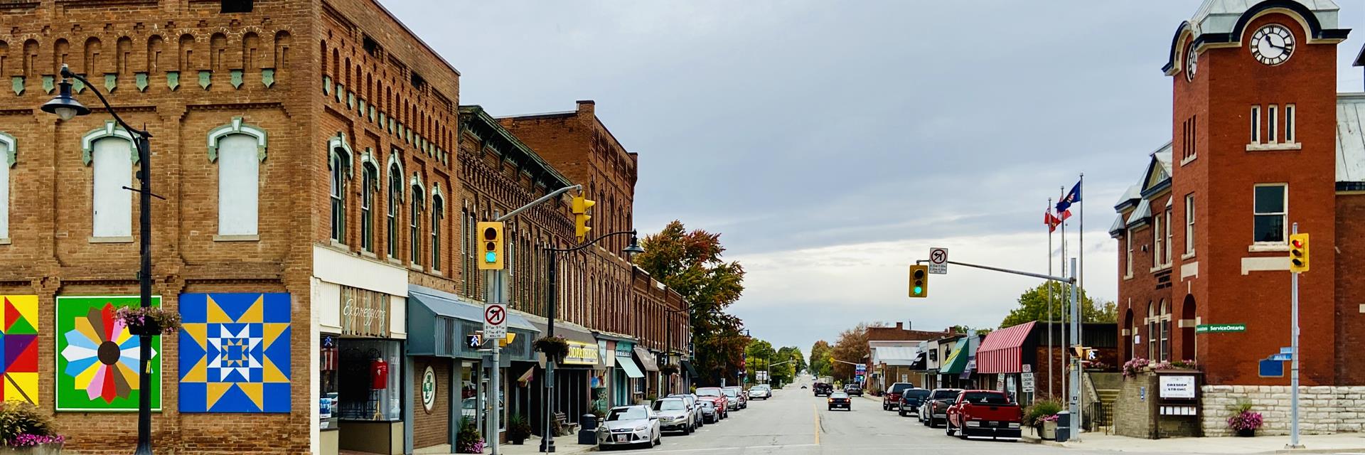 Downtown street with historical buildings and barn quilts along the side.