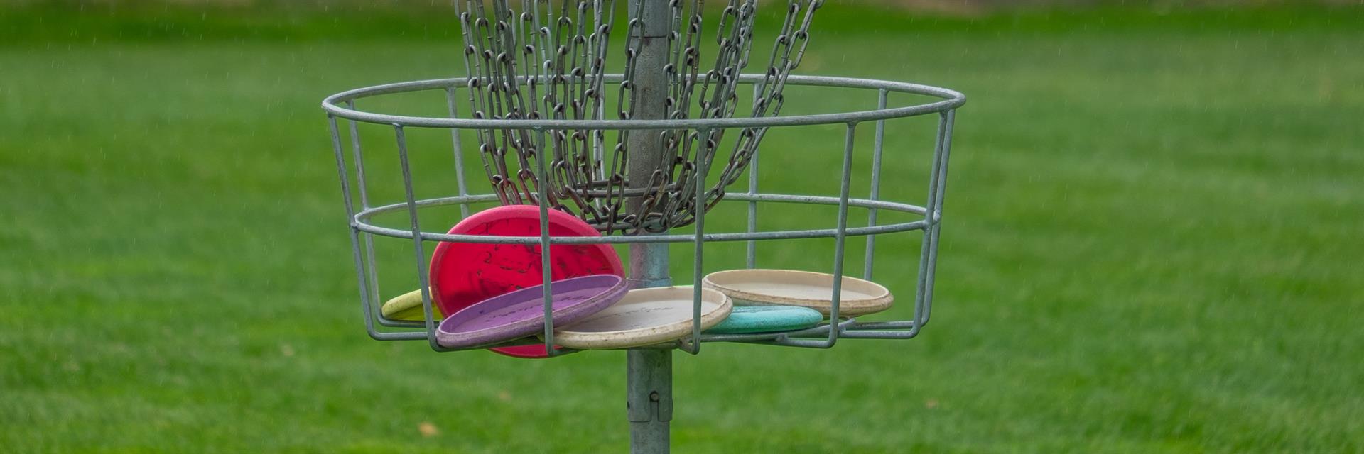 Disc golf basket full of discs.