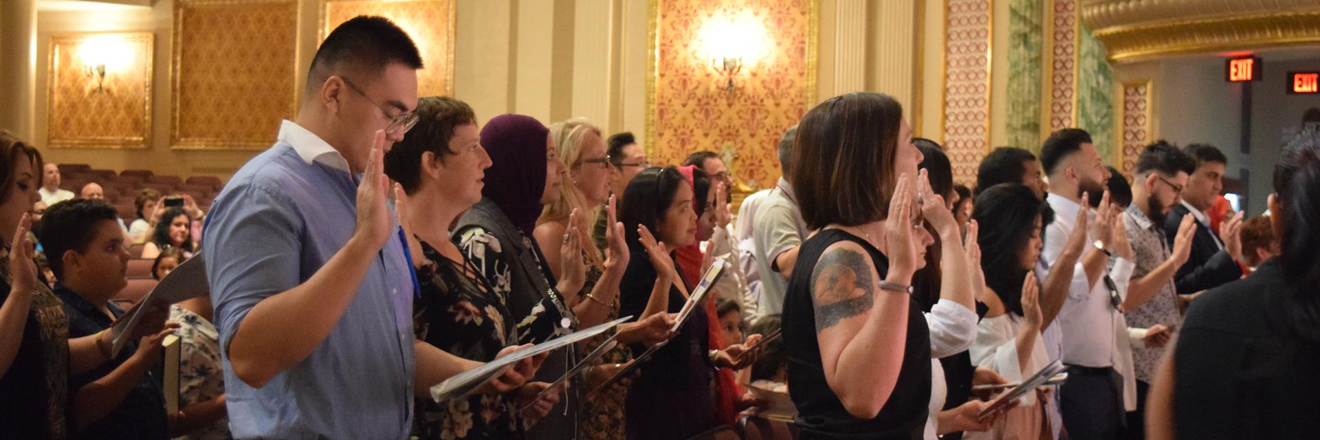 Group of people swear the oath at citizenship ceremony