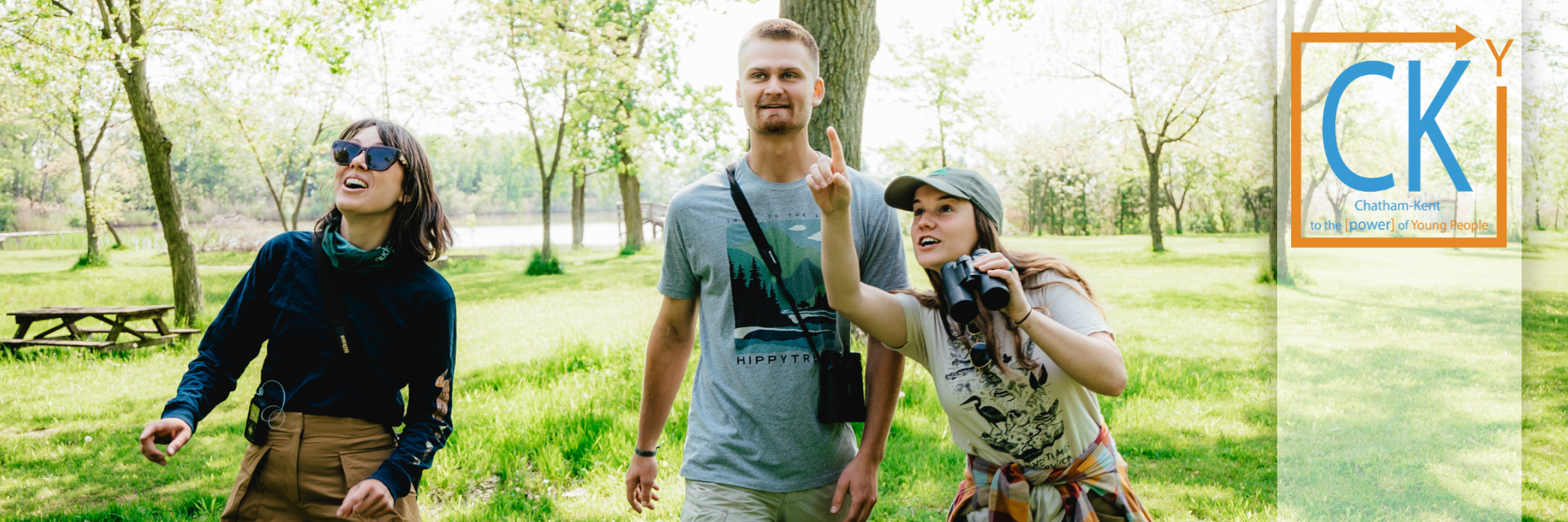 Two people meeting at a cafe with laptops on the table and a notebook.