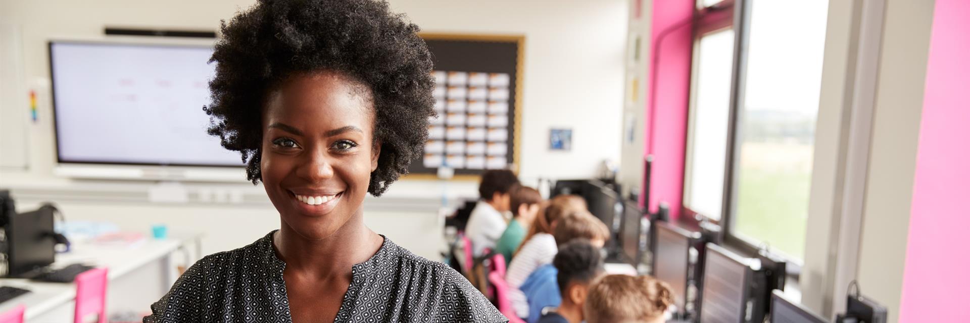 Teacher in a classroom with students on computers.