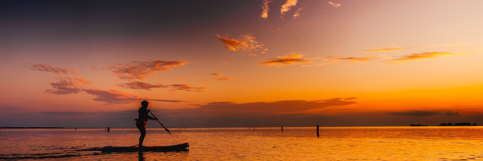paddler on water in sunset