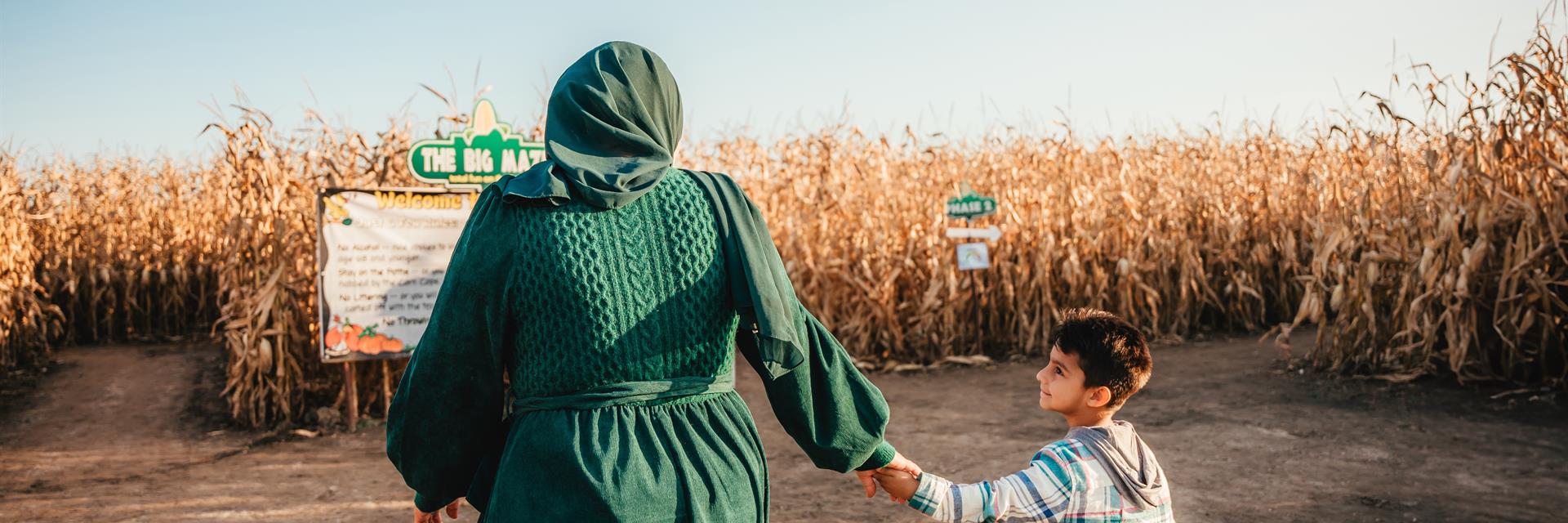 woman and child heading into a corn maze in the fall 