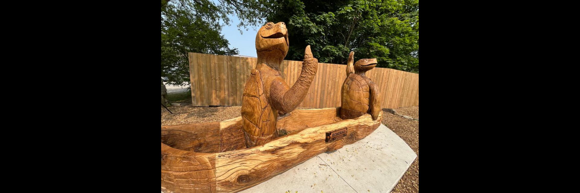 carved wood sculpture of turtles in a canoe 