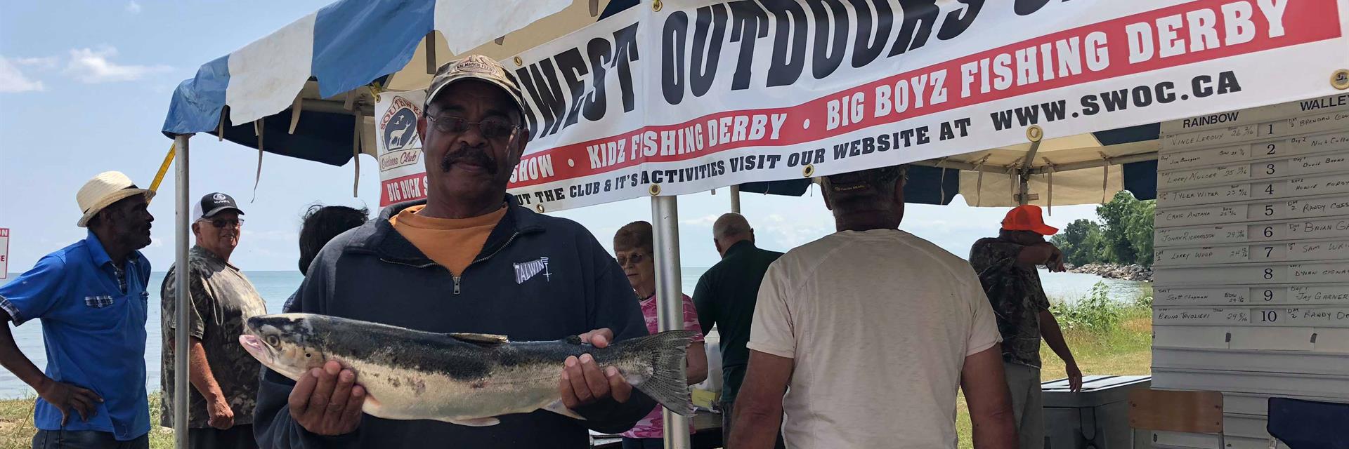 man holding a fish at a fishing tournament in Chatham-Kent