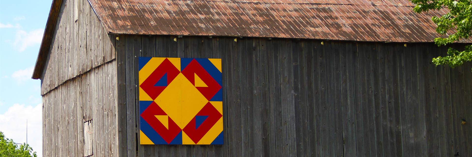 a barn quilt attached to the side of a barn on the east kent barn quilt trail