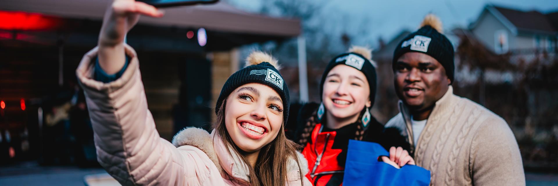 three people taking a selfie at a winter market