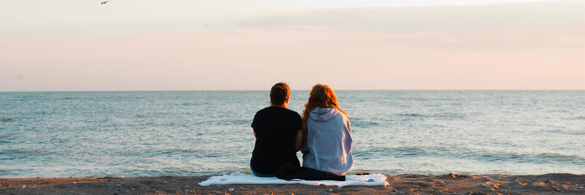 a couple sitting on a beach in chatham-kent