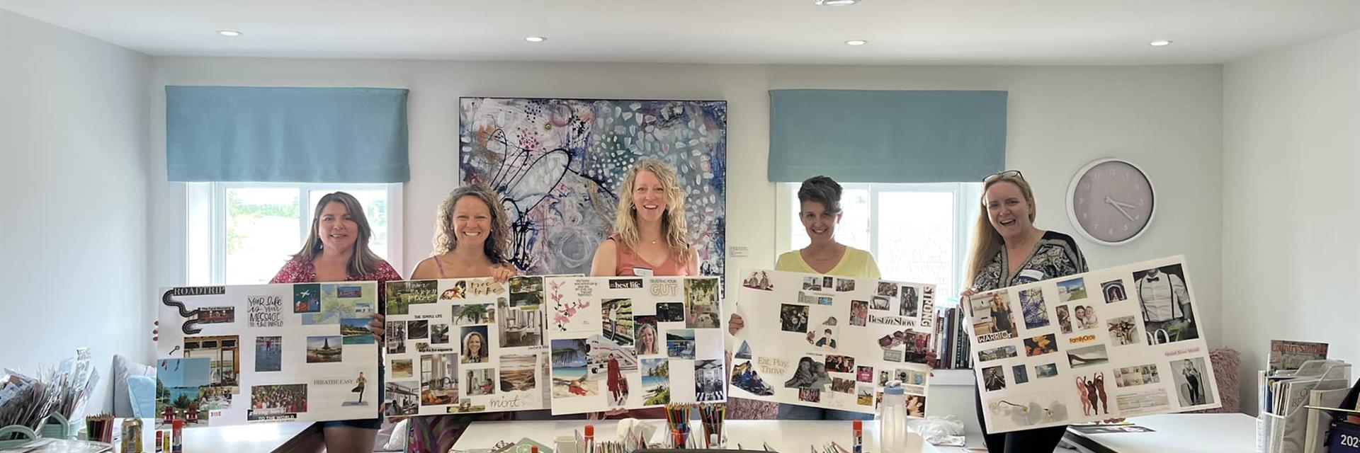 a group of women holding vision boards in a studio