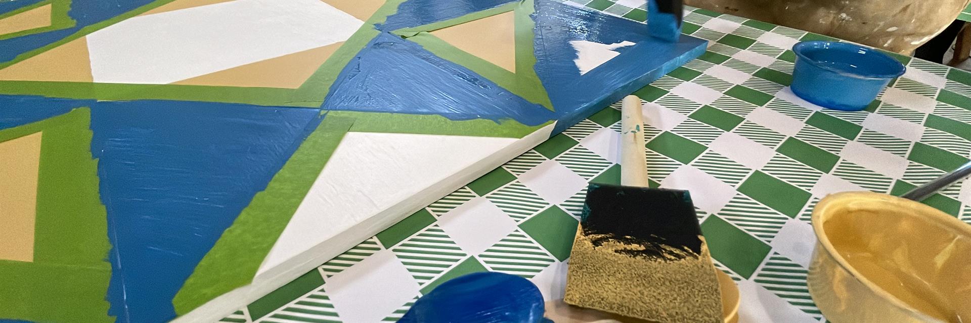 person painting a barn quilt