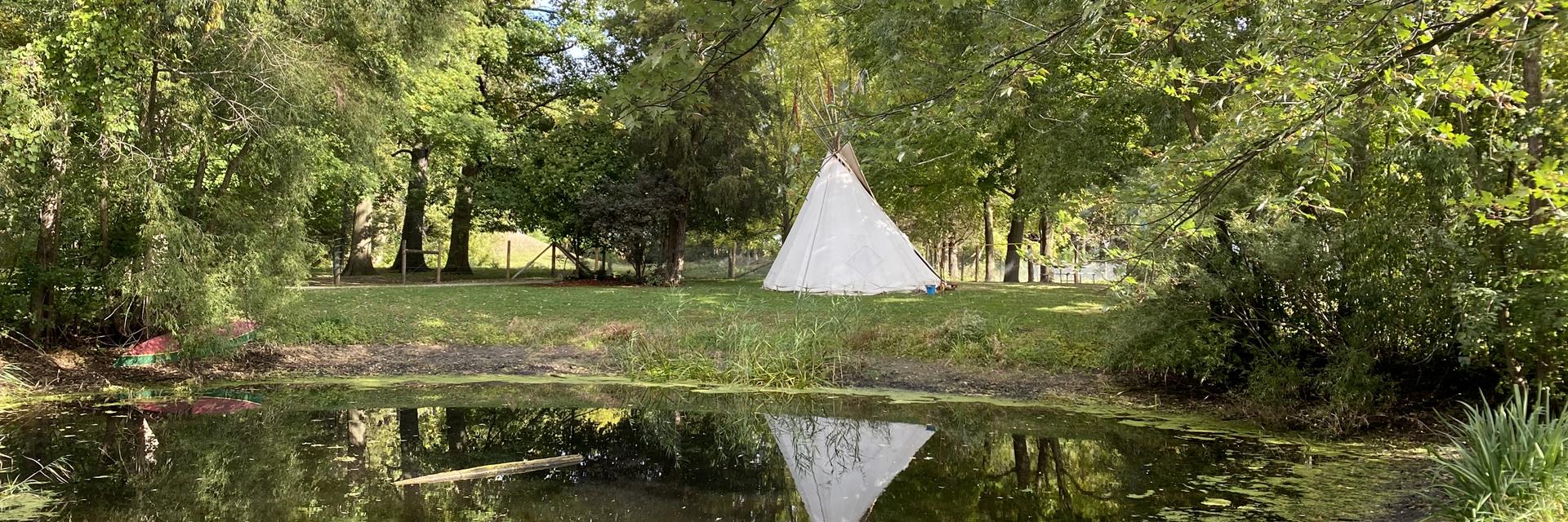 tipi with water and grass